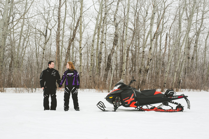 adventurous couple with their skidoo snowmobile engagement photo