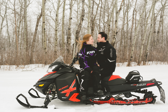 photo of fun couple on their skidoo during their winter engagement session