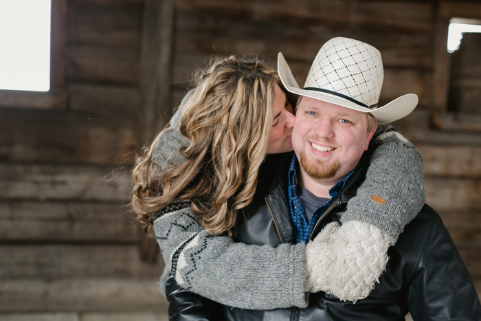 bride to be kisses her cowboy groom on the cheek photo