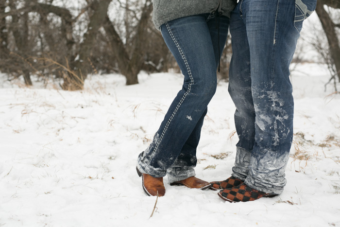 photo of engaged couples snow covered blue jeans and cowboy boots