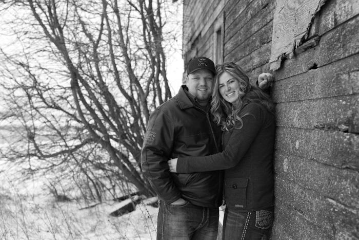 engagement photo against rustic barn