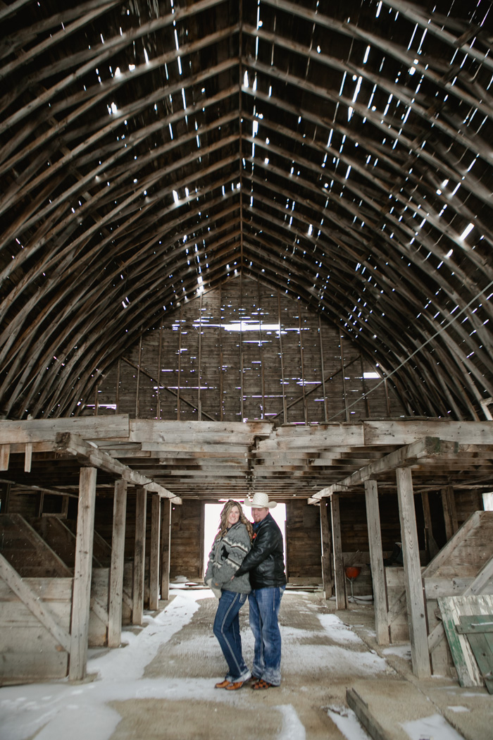 engagement photo of couple in a large rustic barn