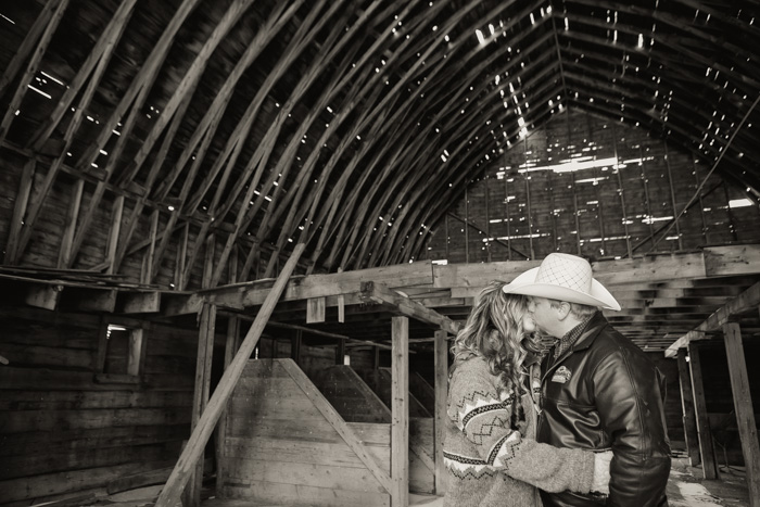photo of couple kissing in rustic barn