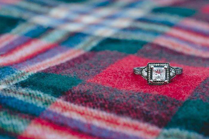 photo of engagement ring on plaid blanket
