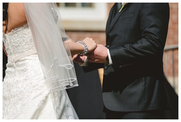 photo of bride and groom holding hands during ceremony