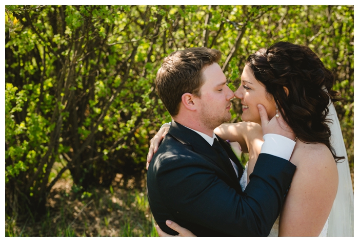 photo of bride and groom by the woods touching noses