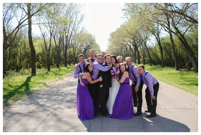 fun photo of bridal party hugging bride and groom