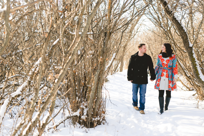 photo of canadian couple walking in the snow covered woods