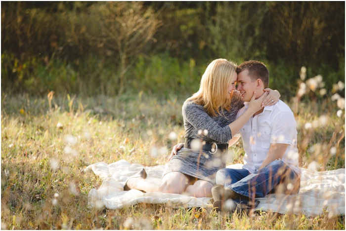 photo of couple sitting on a picnic blanket