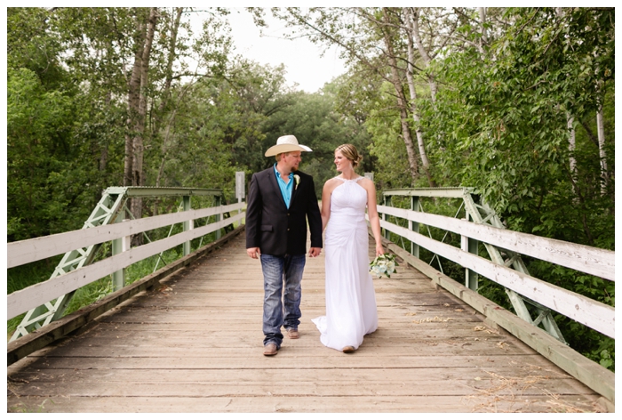 photo of bride and groom walking along a bridge
