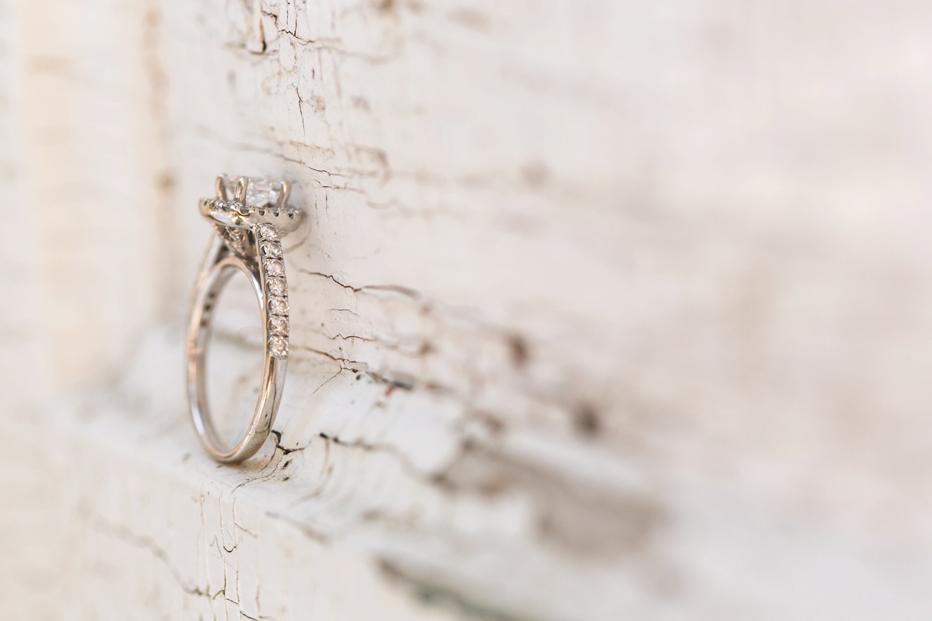 diamond engagement ring against rustic white backdrop