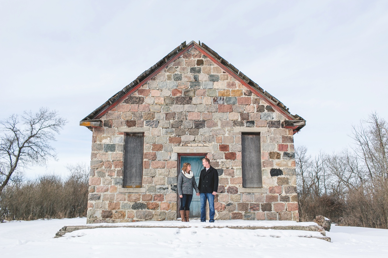 photo of couple in front of an adorable old stone country school
