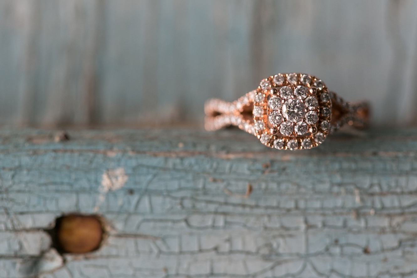 Michael Hill rose gold engagement ring on rustic blue weathered wood photos