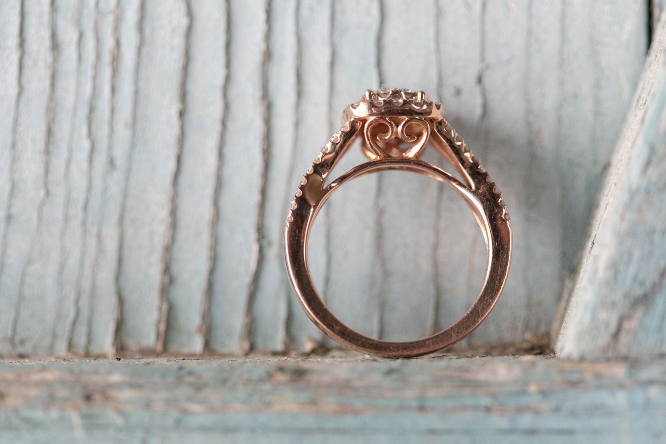 Michael Hill rose gold engagement ring on rustic blue weathered wood photo