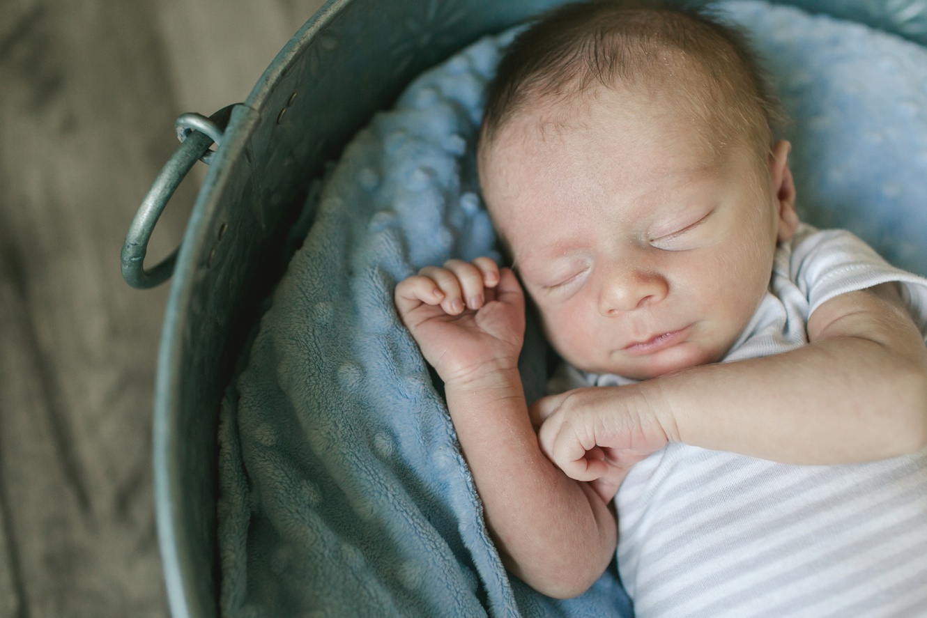 newborn baby boy sleeping on a blue blanket photo