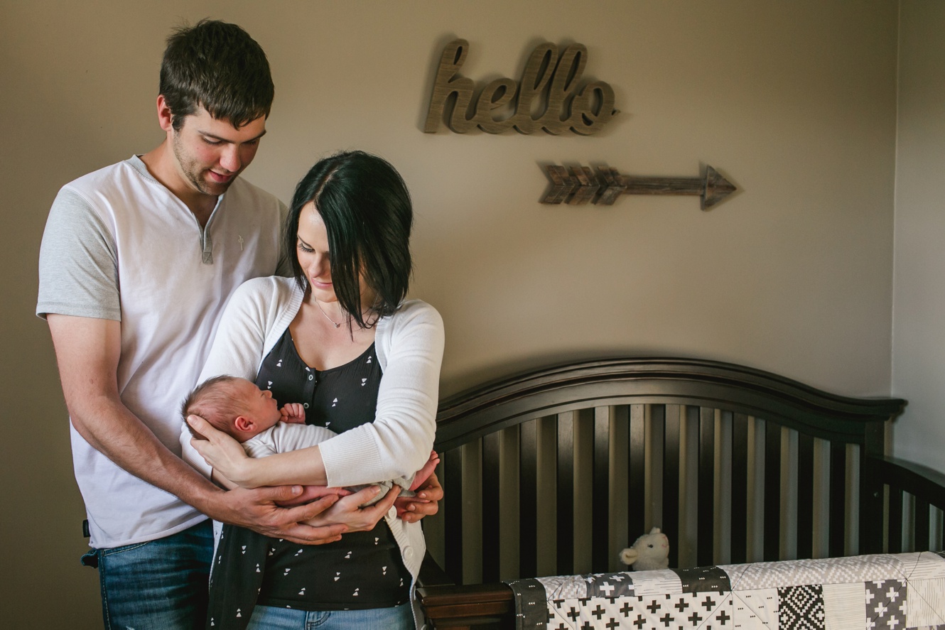 Photo of newborn with parents in nursery photo