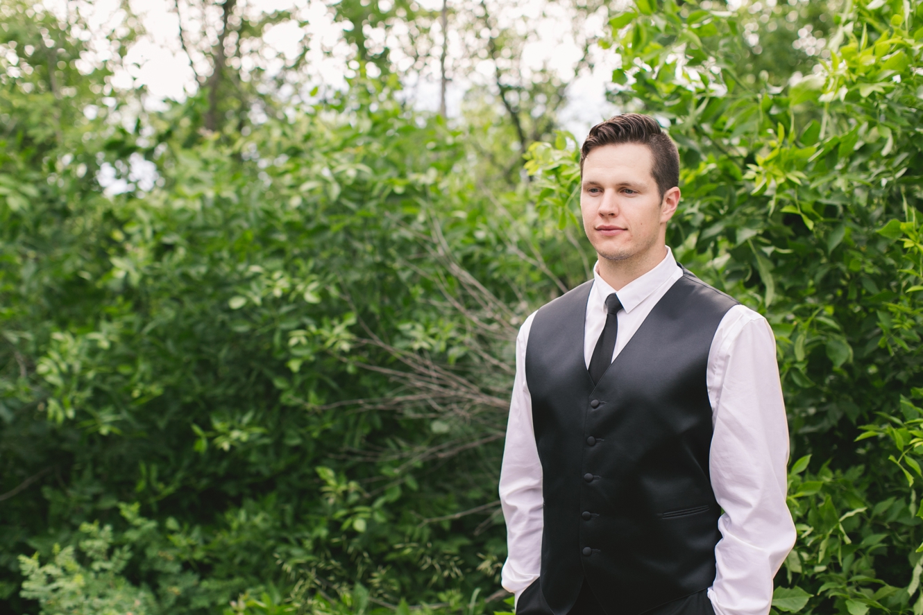 handsome groom wearing black tie and black vest photo