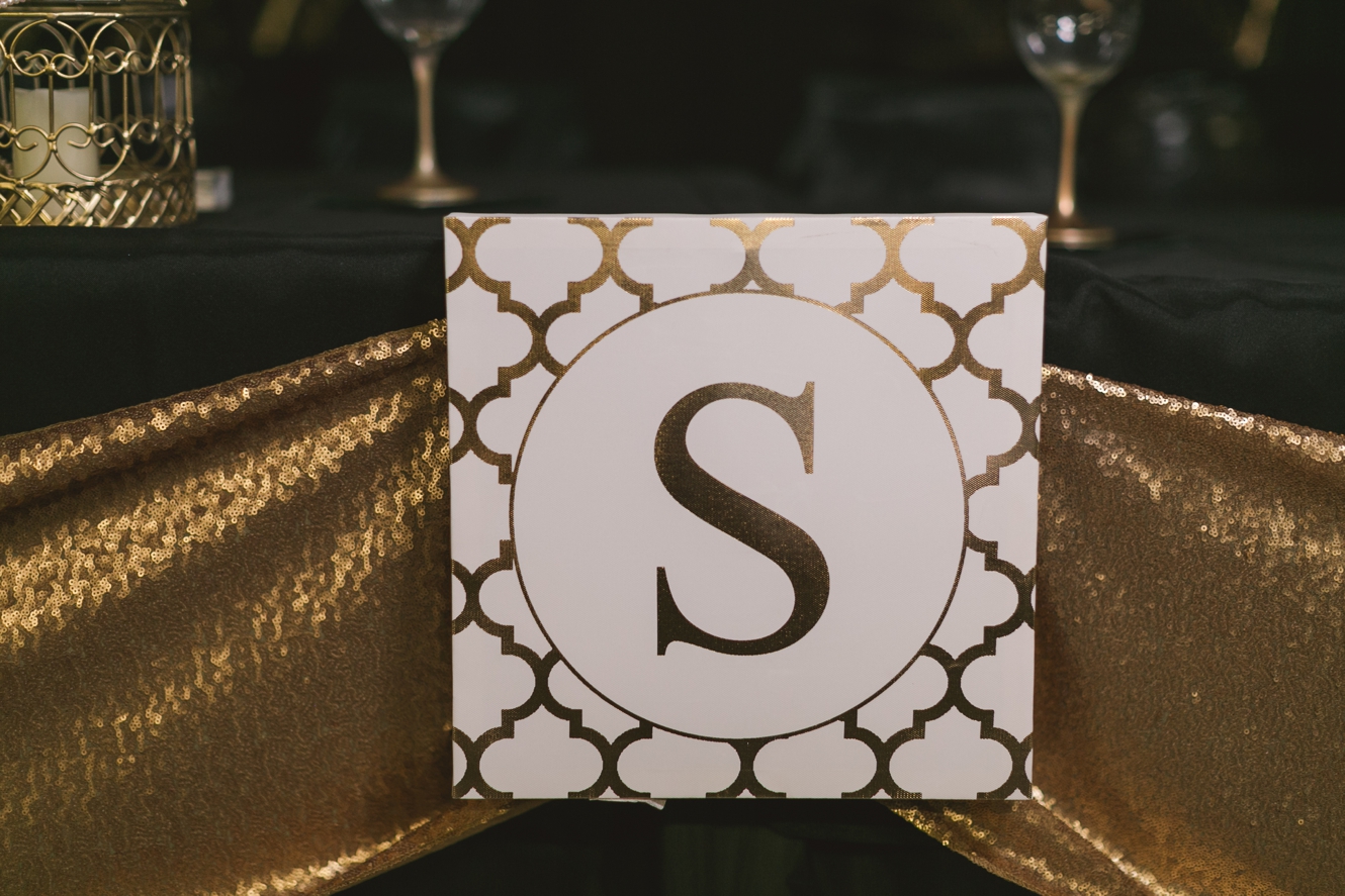 bride and groom gold initial on head table photo