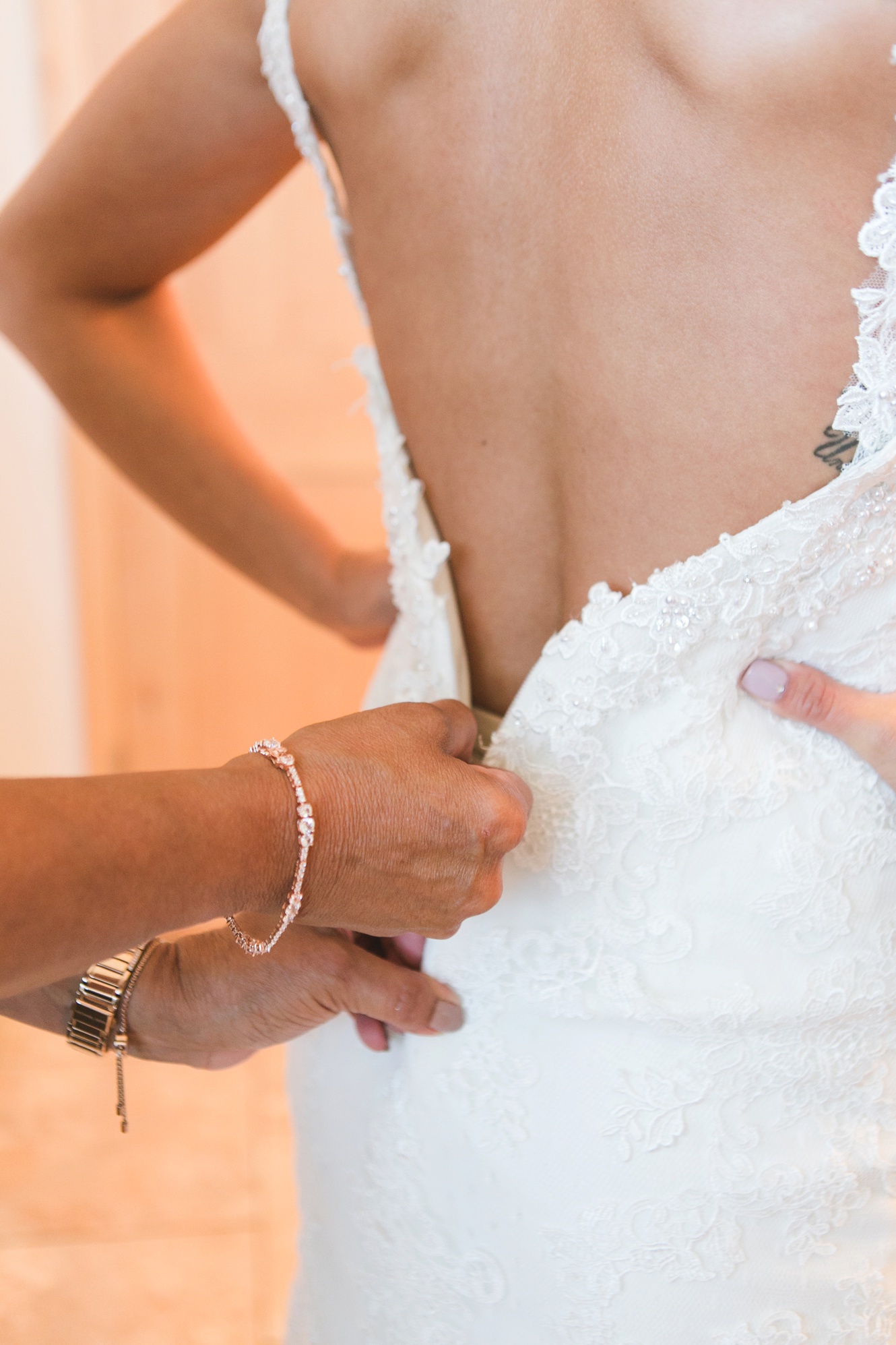 Bride getting zipped into her dress photo