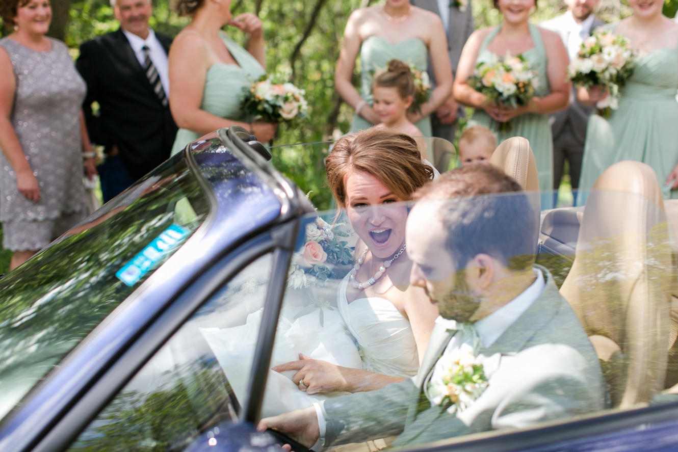 surprised bride in a sports car after her wedding ceremony photo- fun getaway car for wedding 