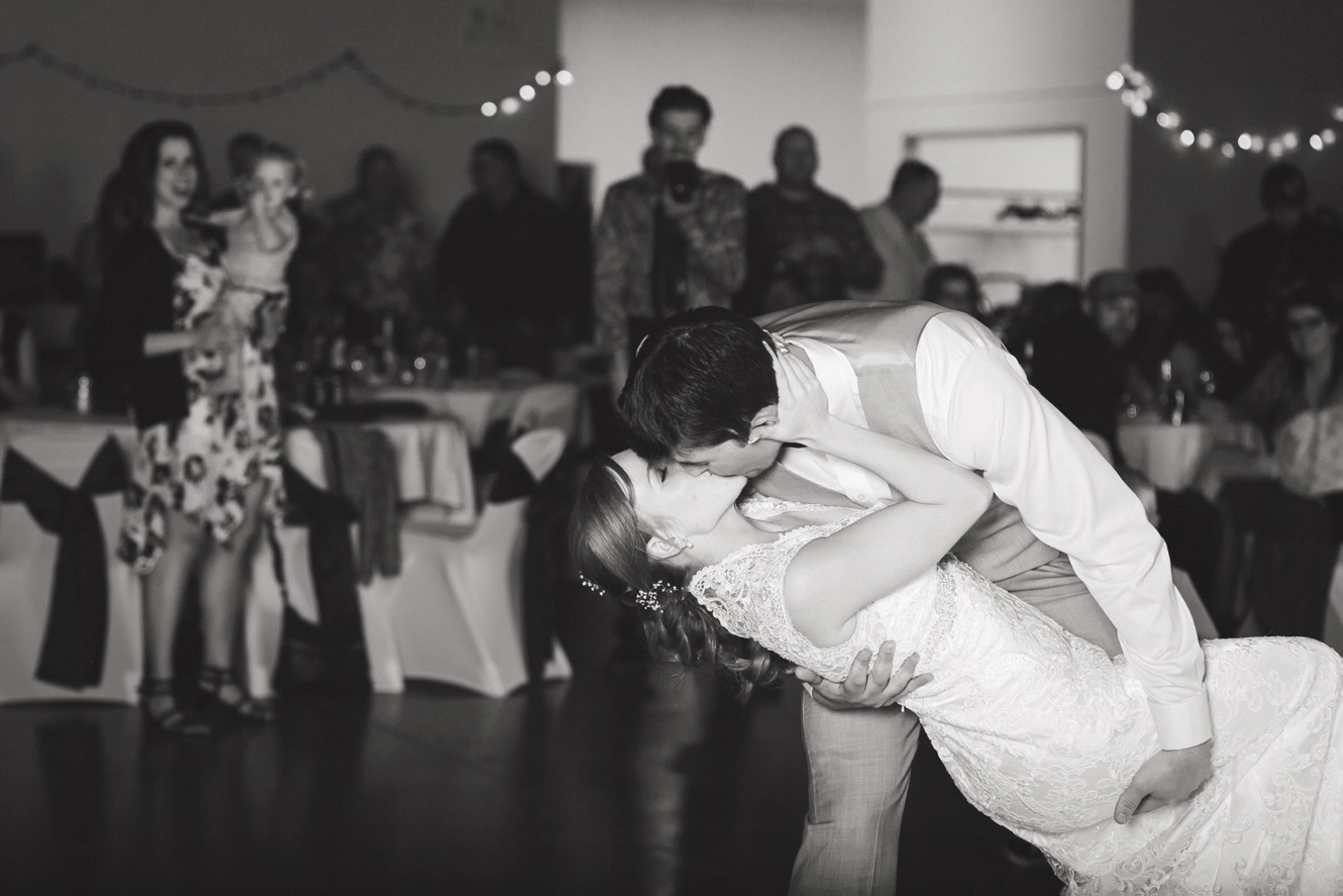 bride and groom dip and kiss photo black and white