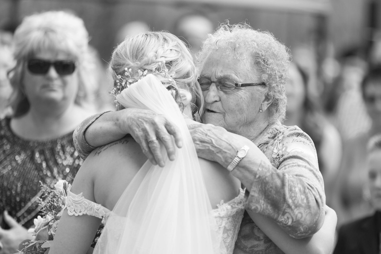 Grandma whispering to bride photo