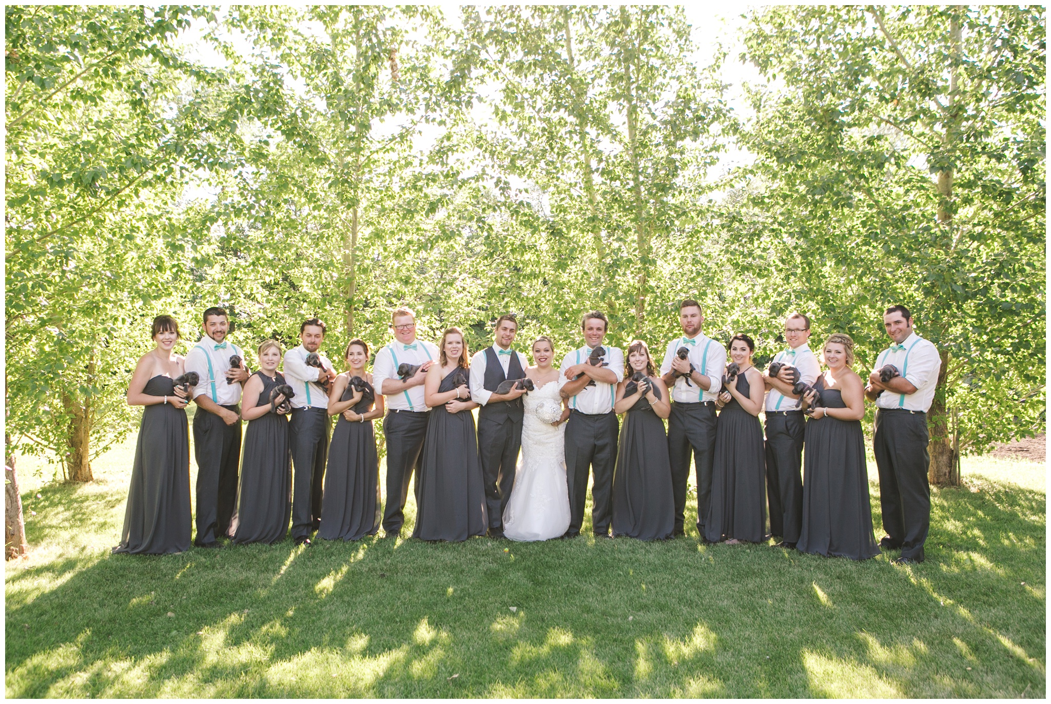 Bridal party holds puppies at wedding photo