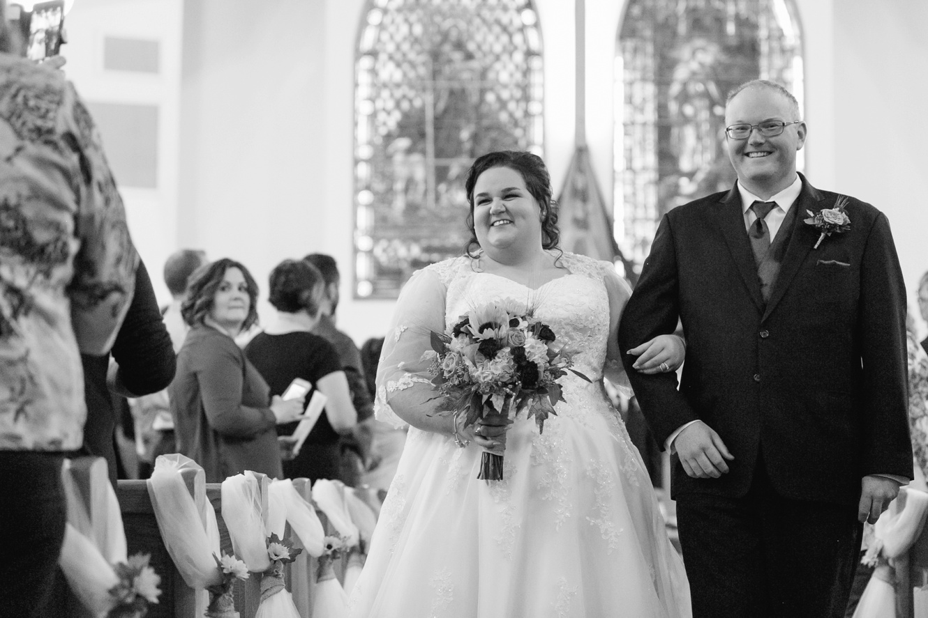 Black and white photo of bride and groom leaving church photo