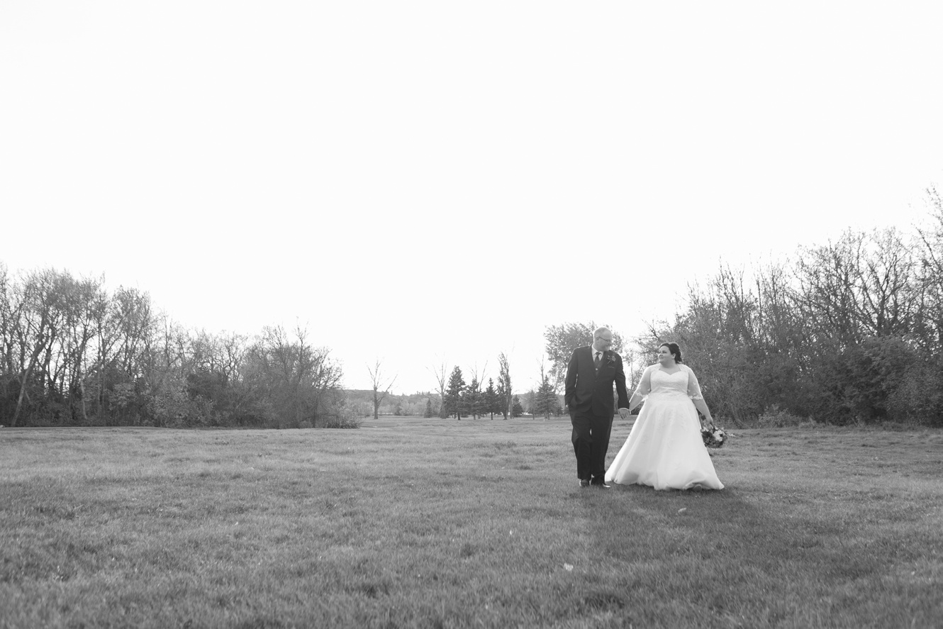 Black and white photo of bride and groom walking