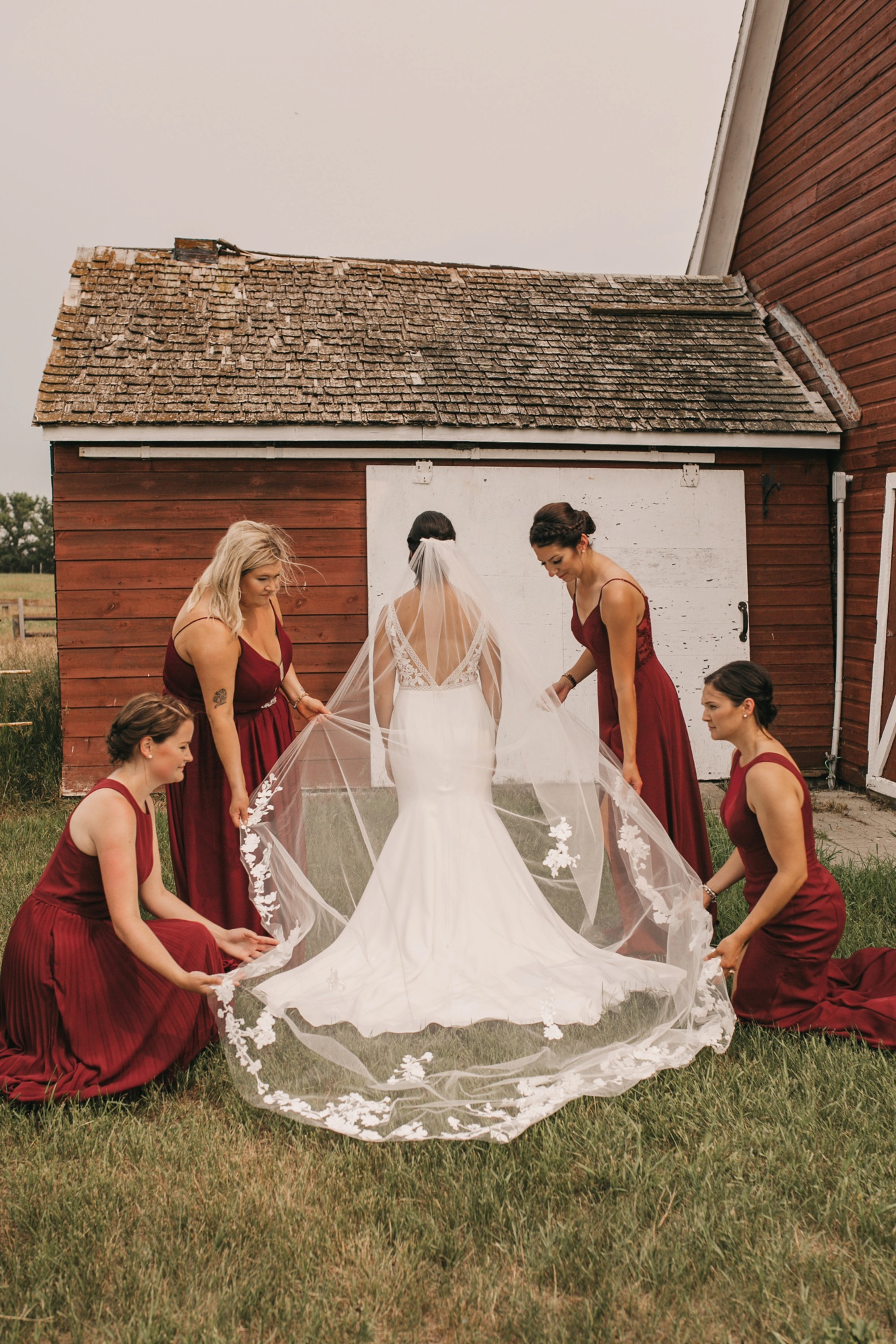 Photo of bridesmaids fixing brides veil