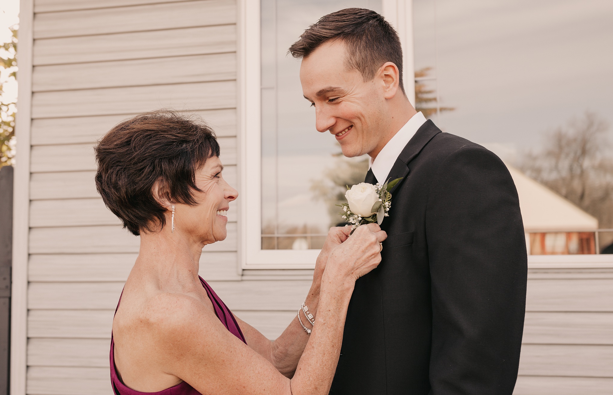 Mother of groom pinning on boutonniere photo